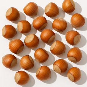 May include: A close-up of twenty-one hazelnuts, showing their smooth, brown shells and light tan, textured tops. The nuts are arranged on a white surface, with shadows adding depth. The image highlights the natural details of the nuts, a common ingredient in baking.
