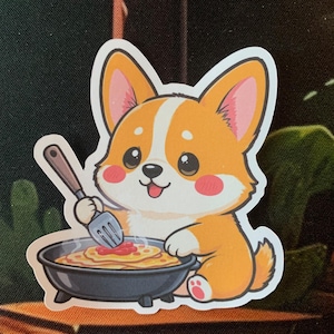 Könnte beinhalten: Ein Aufkleber mit einem Cartoon-Corgi-Hund mit orange-weißem Fell, rosa Ohren und rosigen Wangen. Der Corgi hält eine Gabel und serviert Spaghetti aus einer kleinen schwarzen Pfanne. Der Aufkleber hat einen weißen Rand.