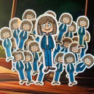 Könnte beinhalten: Eine Ansammlung von Aufklebern mit einer Cartoonfigur mit braunen Haaren, Brille, einer blauen Jacke und Hose. Die Aufkleber haben einen weißen Rand und sind auf einer Oberfläche verstreut.