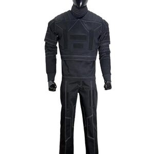 May include: A black tactical-style two-piece outfit consisting of a long-sleeved top with a high collar and matching trousers. The garment features prominent white contrast stitching, structured shoulder panels, and rectangular hook-and-loop patches.