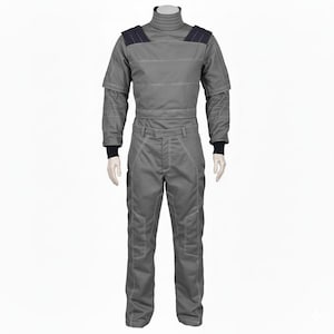 Puede incluir: Mono gris con cuello alto y detalles negros en los hombros y muñecas. El traje tiene costuras blancas y una cremallera frontal. El mono está diseñado con múltiples bolsillos y un ajuste a medida.