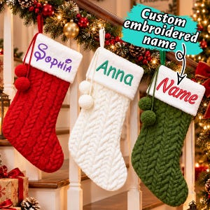 Può includere: Tre calze natalizie in maglia a trecce nei colori rosso, bianco e verde, ciascuna con un risvolto in peluche bianco. La calza rossa è ricamata con 'Sophia', quella bianca con 'Anna' e quella verde con 'Name'. Ognuna ha due pon-pon abbinati.