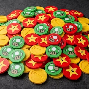 May include: A collection of colourful game tokens with iconic symbols. The tokens feature red stars, green mushrooms, and yellow coins. These tokens are likely from a popular video game.