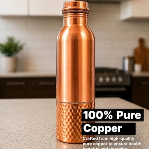Peut inclure: Une bouteille d'eau cylindrique en cuivre poli avec une section supérieure lisse et une texture martelée sur la moitié inférieure. La bouteille dispose d'un bouchon à vis assorti et porte le texte 100% Pure Copper.