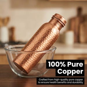 May include: A hammered copper water bottle with a metallic finish, resting inside a clear glass bowl. The bottle features a cylindrical body and a screw-top lid. Text on the image reads 100% Pure Copper and Crafted from high-quality pure copper.