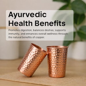 May include: Two hammered copper tumblers with a metallic finish. Above the tumblers, a white text box reads: Ayurvedic Health Benefits. Promotes digestion, balances doshas, supports immunity, and enhances overall wellness through the natural benefits of copper.