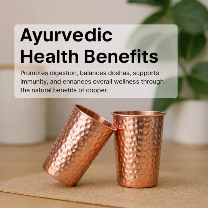 K&ouml;nnte beinhalten: Zwei kupferfarbene Becher mit geh&auml;mmerten Strukturen. Die zylindrischen Becher haben ein gl&auml;nzendes Finish. Der Text &uuml;ber den Bechern lautet "Ayurvedic Health Benefits". Der Text darunter beschreibt die Vorteile von Kupfer.