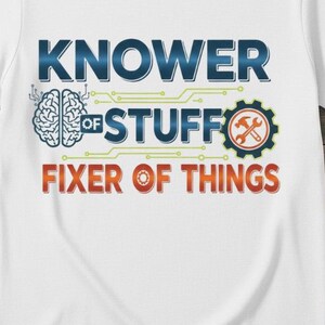 May include: White t-shirt with the text "KNOWER OF STUFF FIXER OF THINGS". The design includes a brain graphic, a gear with a wrench, and circuit board-style lines. The text is in blue, orange, and green.