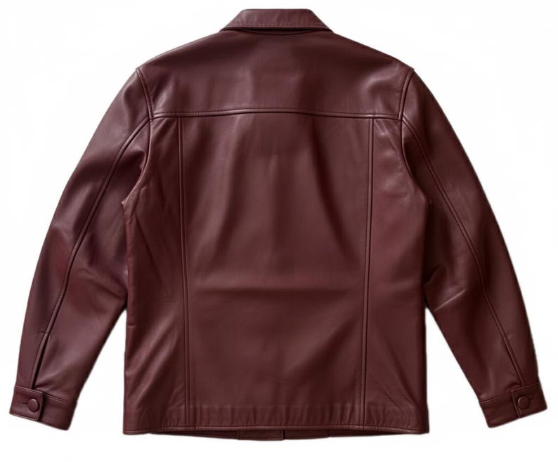 May include: A burgundy leather jacket with a collared neckline and buttoned cuffs. The back view of the jacket shows vertical seams and a tailored fit. The jacket has a classic, timeless design.