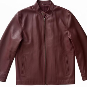 May include: A burgundy leather jacket with a stand-up collar and a full-length zipper. The jacket has two front pockets and long sleeves. The leather has a smooth, matte finish.
