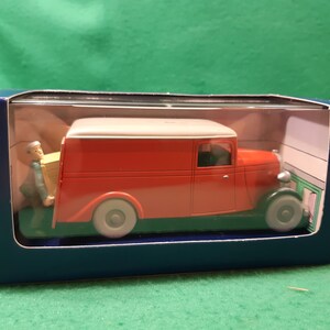 以下が含まれることがあります： 主に赤色でクリーム色の屋根のヴィンテージ配送バンのダイキャストモデル。バンはグレーのホイールで、青い箱に入っています。箱を運んでいる男性の小さなフィギュアが含まれています。