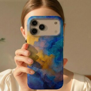 May include: A smartphone case with a vibrant abstract design. The case features a blend of blue, yellow, and white colors, creating a watercolor effect. The case has a protective bumper around the camera lenses.