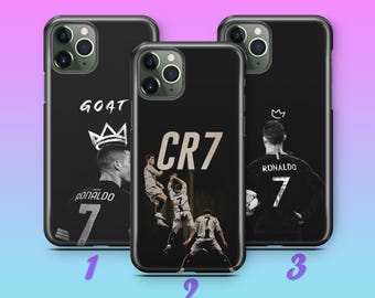 Puede incluir: Fundas de teléfono negras con imágenes de un futbolista. Una funda tiene la palabra "GOAT" y una corona, otra "CR7", y la tercera el nombre y el número del jugador.