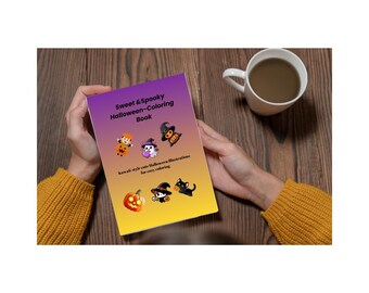 May include: A coloring book titled "Sweet & Spooky Halloween-Coloring Book" with kawaii-style illustrations. The cover features a gradient of purple and yellow with cartoon images of Halloween characters. A white mug with a brown liquid sits on a wooden surface.