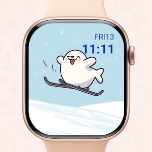 May include: A smartwatch with a light blue screen displaying a cartoon seal skiing down a snowy hill. The screen also shows the time 11:11 and the date FRI13. The watch has a gold case and a light pink band.