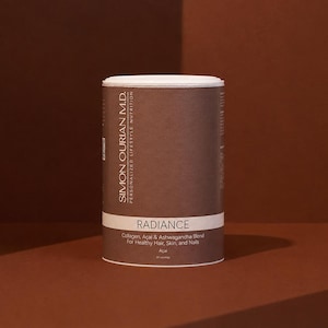May include: A cylindrical brown container of Simon Ourian M.D. Radiance supplement powder. The label features white text reading Radiance, Collagen, Acai & Ashwagandha Blend For Healthy Hair, Skin, and Nails, and Personalized Lifestyle Nutrition.