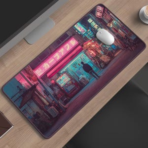 Pode incluir: Um tapete de secretária retangular com uma ilustração vibrante e detalhada de uma rua urbana noturna com iluminação néon rosa e azul, texto japonês num letreiro de loja e a silhueta de uma pessoa perto de uma máquina de venda.