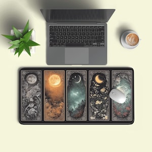 May include: A rectangular desk mat featuring five vertical panels with celestial and botanical illustrations, including moons, stars, trees, and flowers in shades of gray, gold, teal, and black, positioned below a laptop and a white computer mouse.