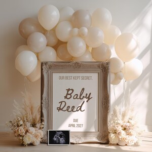 May include: A framed announcement with the text "Our Best Kept Secret. Baby Reed. Due April 2027" is surrounded by cream and beige balloons, pampas grass, and floral arrangements. An ultrasound image is displayed below the frame.