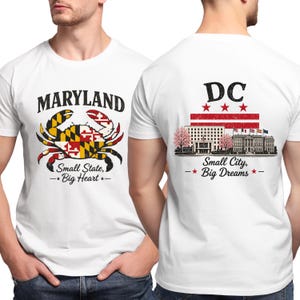 May include: White t-shirt featuring a Maryland crab design with the text "MARYLAND" above and "Small State, Big Heart" below. The back of the shirt displays "DC" with a flag design and the text "Small City, Big Dreams."