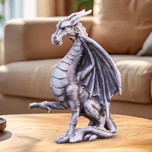 May include: A detailed, gray dragon figurine with outstretched wings and a seated pose. The sculpture has textured scales, a long neck, and a detailed face. The dragon is a fantasy-themed decorative item.