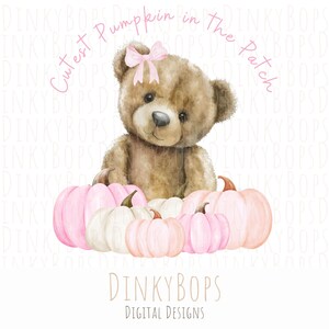 Puede incluir: Un oso de peluche marrón con un lazo rosa se sienta sobre una colección de calabazas rosas y blancas. También se ve el texto "Cutest Pumpkin in the Patch" y "DinkyBops Digital Designs".