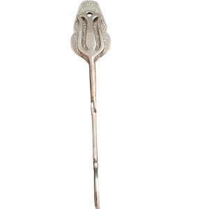 Könnte beinhalten: Ein silberfarbenes Haar-Accessoire aus Metall mit einer länglichen, spitz zulaufenden Form, einem dekorativen, geprägten Blumenmuster am breiteren oberen Teil und einem glatten, schlanken Stiel, der sich am unteren Ende leicht biegt und ein glattes Finish aufweist.