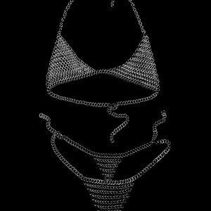 May include: A silver chainmail bikini set against a black background. The set includes a halter top and a thong-style bottom, both constructed from small, interlocking metal rings. The chains are reflective, creating a shimmering effect.