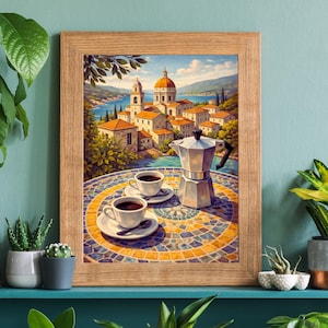May include: A framed print depicts a picturesque Italian coastal town with a red-domed church. Two cups of coffee and a silver stovetop espresso maker sit on a mosaic-tiled table. The artwork is framed in a light brown wooden frame.