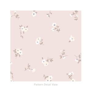 May include: A pattern detail view displaying a repeating floral design. The pattern features small, white flowers with yellow centres and blue accents, alongside gray-brown leaves, set against a soft pink background. The text "Pattern Detail View" is at the bottom.