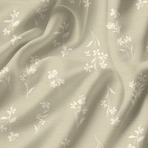 May include: A beige fabric with a floral pattern. The design features white, stylized flowers and leaves scattered across the surface. The fabric has a soft, flowing appearance with subtle folds and shadows, creating a sense of depth and texture.