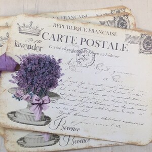 May include: A vintage postcard with a lavender bouquet in a hat, featuring the text "No 181 Lavender" and "Carte Postale" in French. The postcard has a worn, aged look and is printed on thick paper.
