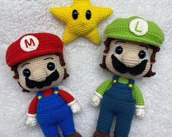 May include: Crocheted figures of Mario and Luigi, with a yellow star. Mario wears a red hat with a white "M", blue overalls, and brown shoes. Luigi has a green hat with a white "L", blue overalls, and brown shoes. The star is yellow.