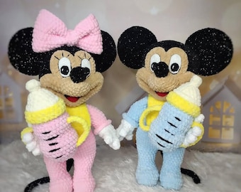 May include: Two plush Mickey Mouse and Minnie Mouse dolls, each holding a baby bottle. Minnie wears a pink outfit and bow, while Mickey is in blue. Both have black ears, tan faces, and yellow accents.