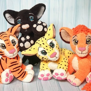 May include: A group of handmade crochet animal plush toys. The toys include a black panther, a tiger with orange and black stripes, a yellow leopard with black spots, and an orange lion. Each toy has detailed features and is made with soft yarn.