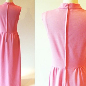 May include: A sleeveless pink maxi dress with a high neckline and a back zipper closure.