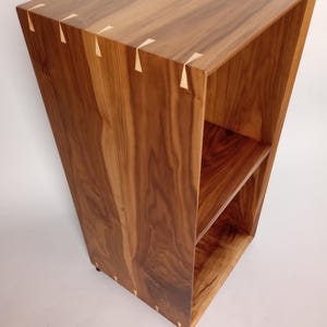 May include: A set of three ceramic mugs with a speckled, cream-colored glaze. Each mug features a different hand-painted floral design in shades of blue, green, and yellow. The mugs have a simple, rounded shape and a comfortable handle.