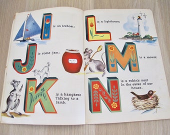 May include: Open book illustration featuring the letters I, J, K, L, M, and N. Each letter is decorated with images and text, including an iceboat, jam, a kangaroo, a lighthouse, a mouse, and a robin's nest.