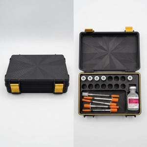 Puede incluir: Un estuche negro con cierres dorados, cerrado y abierto, que revela un conjunto de jeringas, viales y otros suministros médicos. El estuche está hecho de un material duradero y tiene una superficie texturizada. El estuche abierto muestra el contenido bien organizado.