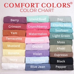 May include: A color chart displaying a variety of Comfort Colors t-shirts. The chart features a range of colors, including Berry, Crimson, Yam, Terracotta, Mustard, Banana, Ivory, White, Island Reef, Crunchberry, Watermelon, Blossom, Orchid, Violet, Chambray, and Blue Jean.