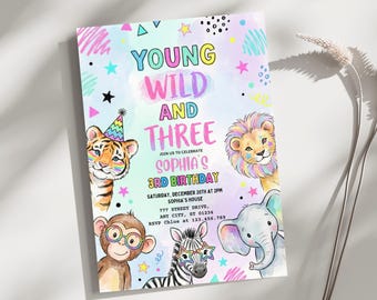May include: A colorful birthday invitation with the text "Young Wild and Three" and the name "Sophia's" in a playful font. The invitation features illustrations of a tiger, lion, monkey, zebra, and elephant. The date, time, and location are also included.