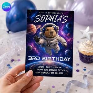 May include: A rectangular birthday invitation card featuring a capybara in a white astronaut suit floating in space. The text reads: JOIN US TO CELEBRATE SOPHIA'S 3RD BIRTHDAY, SUNDAY - JULY 19 - 4:00 PM, 321 GALAXY ROAD, STARVIEW, TX 75024, RSVP TO EMILY AT 555-684-2719.