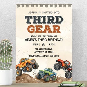 Puede incluir: Una invitación de cumpleaños con un diseño de acuarela. El texto dice "Adrian está cambiando a Tercera Marcha" y "Tercer Cumpleaños de Aiden". Tres monster trucks saltan sobre tierra. Un cactus en una maceta blanca está a la izquierda.