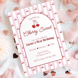 Puede incluir: Una invitación a rayas rosas y blancas con un tema de cerezas. El texto dice "Carter is Cherry Sweet" y anuncia una celebración de primer cumpleaños. Incluye fecha, hora e información de RSVP.