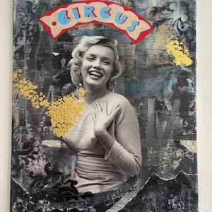 Op de afbeelding: Mixed media kunstwerk met een zwart-wit afbeelding van een lachende vrouw met blond haar. Het woord "CIRCUS" staat in blauwe letters op een rode en bruine banner. Gouden verf en zwarte texturele elementen omringen de centrale afbeelding.