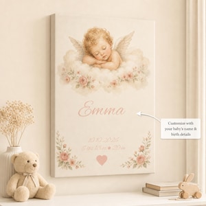 May include: A rectangular canvas print featuring a sleeping baby with angel wings resting on clouds, decorated with pink roses. The text reads Emma, 10.10.2026, 6 lbs 13 oz, 20 in, with a small pink heart. A white arrow points to the text.