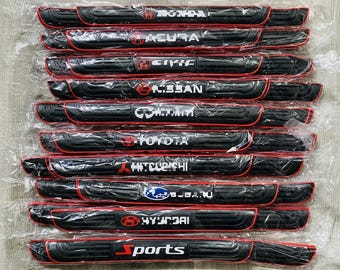 May include: A collection of black car door sill protectors with red trim. Each protector features a different car brand logo in white, including Honda, Acura, Civic, Nissan, Infiniti, Toyota, Mitsubishi, Subaru, Hyundai, and Sports.