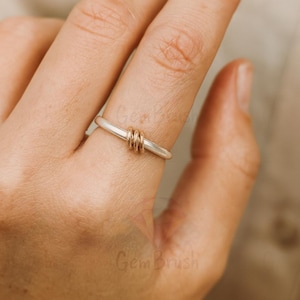 Mixed metal silver and gold bead stacking ring displayed on wooden surface