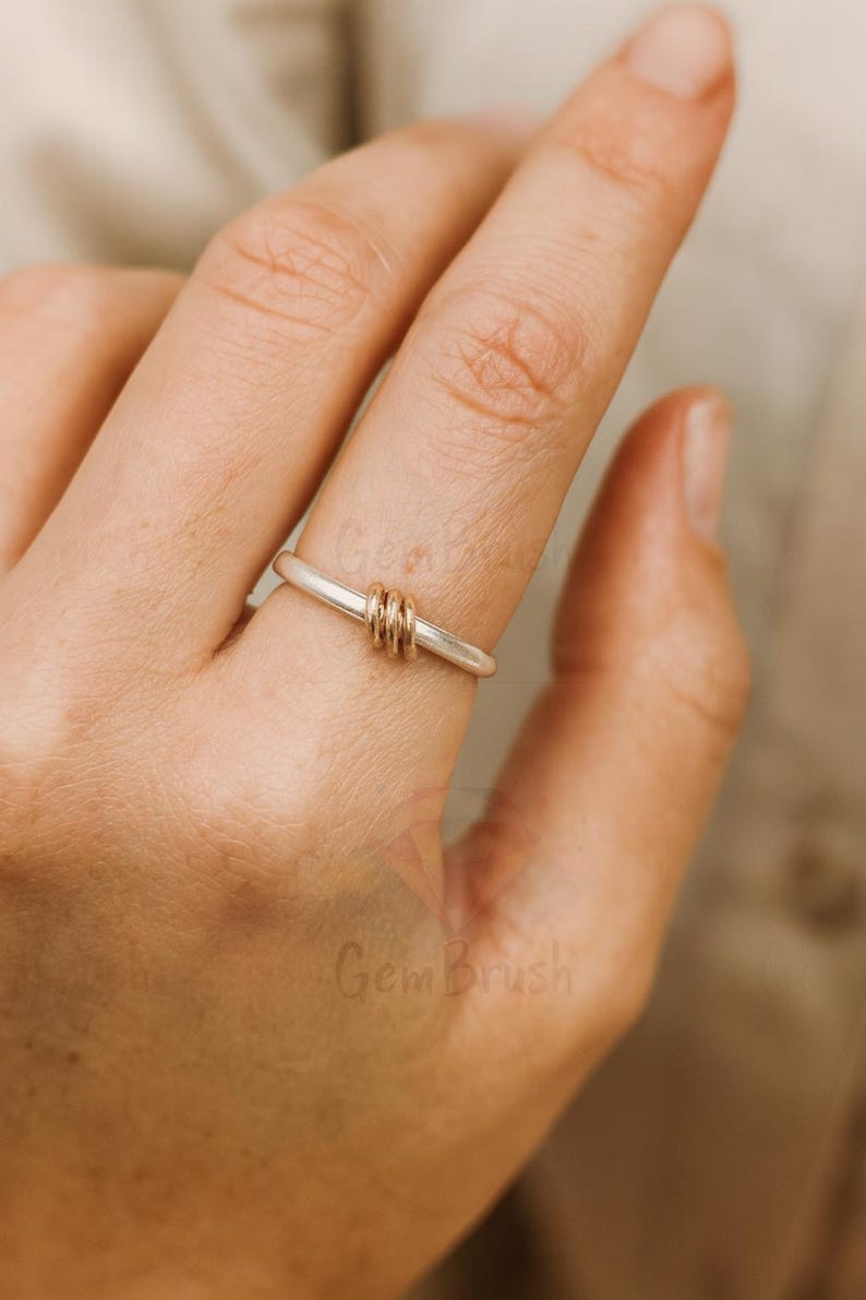 Mixed metal silver and gold bead stacking ring displayed on wooden surface