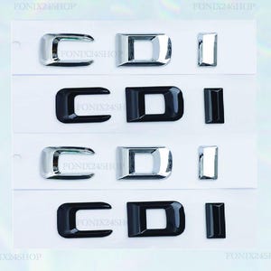 Peut inclure: Quatre ensembles d'emblèmes de voiture CDI. Deux ensembles sont chromés et deux sont noirs. Chaque ensemble comprend une lettre en forme de C, un D carré et un I rectangulaire. Les emblèmes sont affichés sur fond blanc.